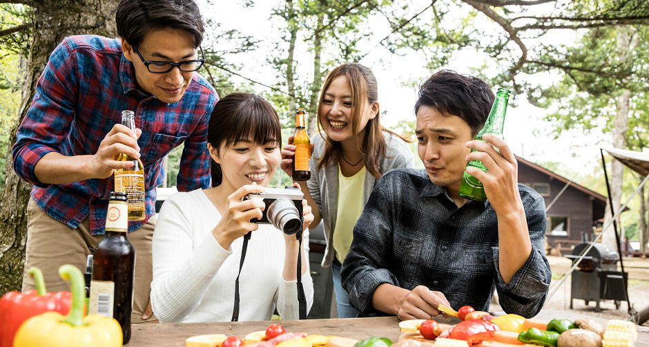 キャンプでの団らんを楽しそうに過ごす男女グループ